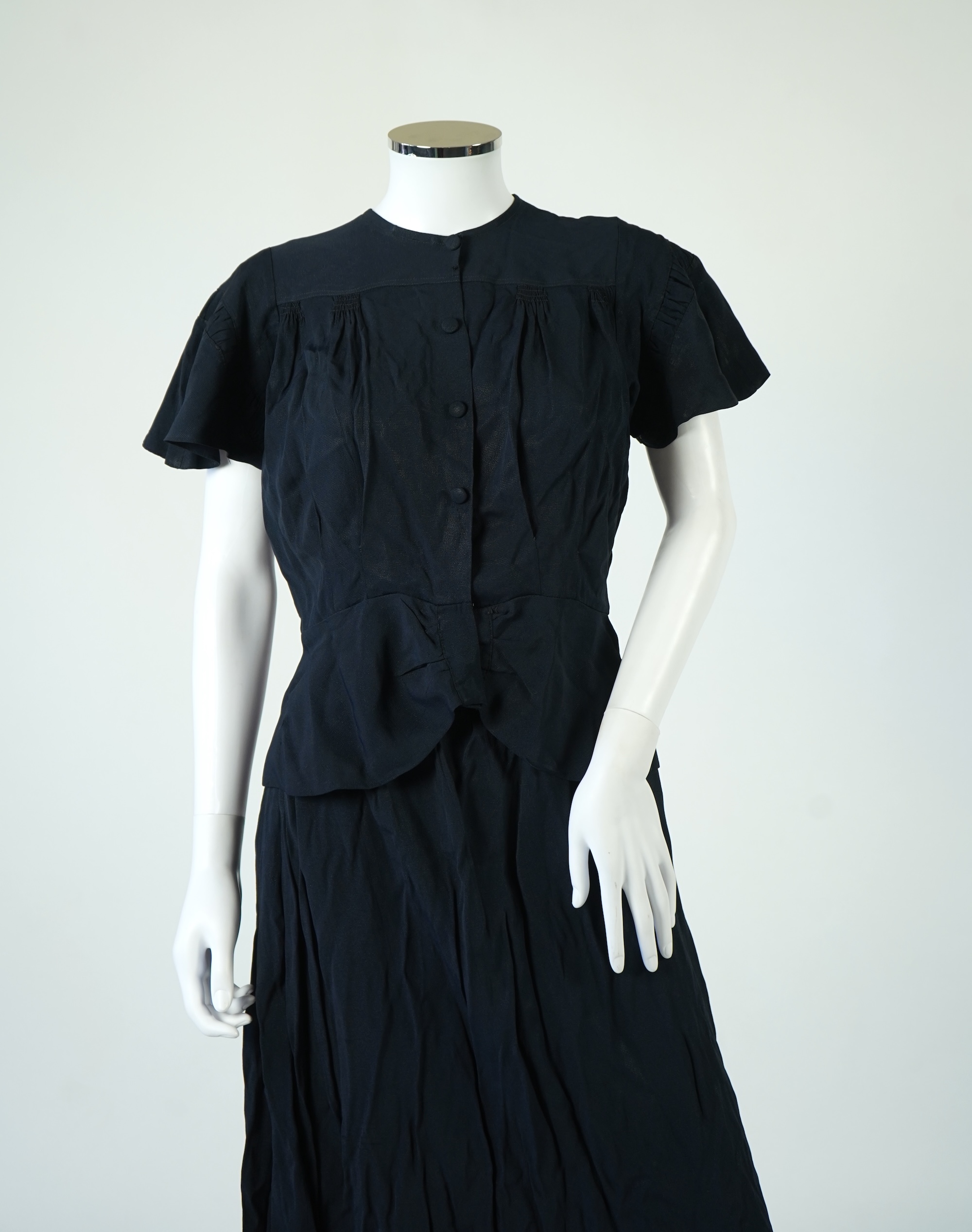 A 1920’s light green silk evening cape with hand batik borders and label: Tito de Canival Mode, together with a navy ladies two piece suit and a maroon satin evening dress. Cape 100cm long. Condition - cape good, navy tw